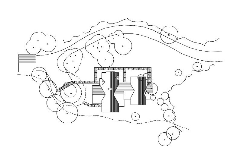 Site plan: the house set lengthways along the contours with a terrace to the open side, the drive curving in from the west to stop short of it, and existing trees drawn close on the wooded sides.