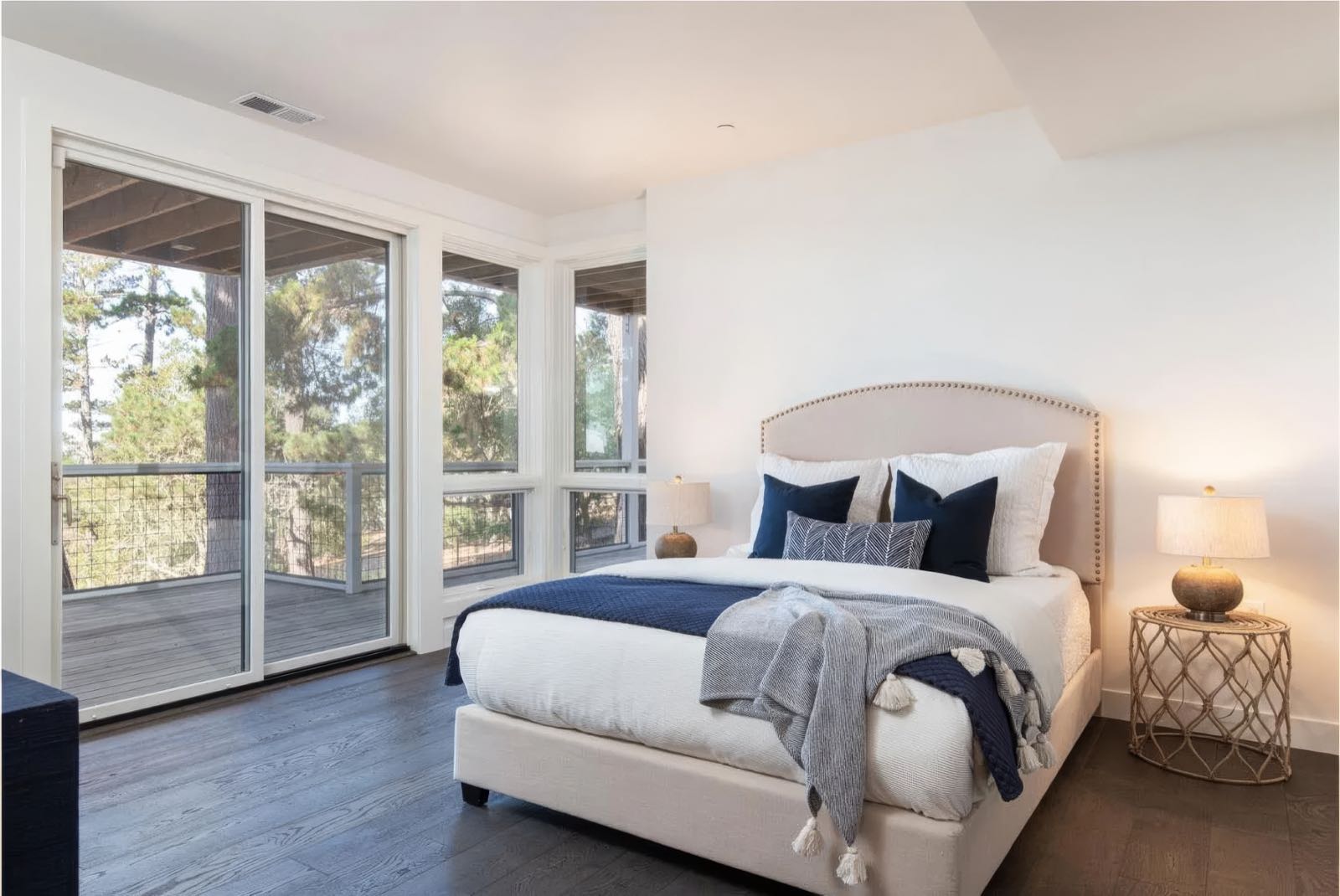 Lower level bedroom with an upholstered headboard and a sliding door onto the deck.