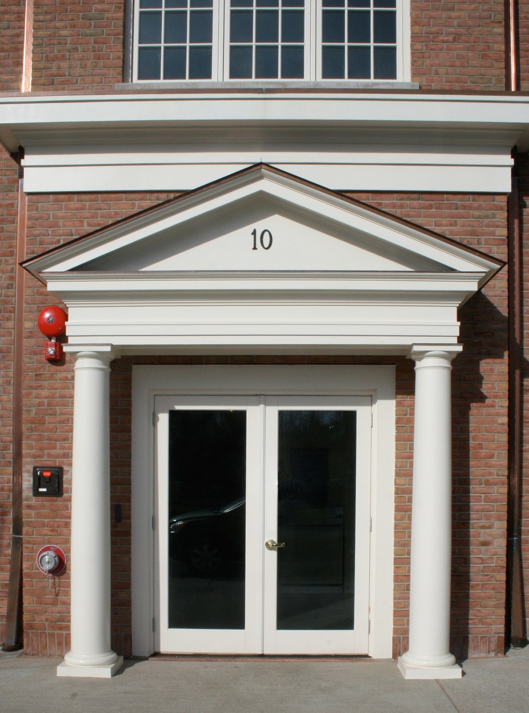 The office entrance: a pedimented door case carried on two columns, with the street number set in the tympanum above the doors.