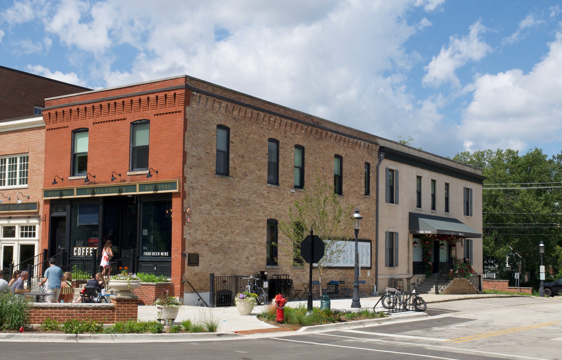 The building on its corner in downtown Lake Bluff, the red brick front holding the coffee roaster and a longer buff brick elevation running back along the side street.