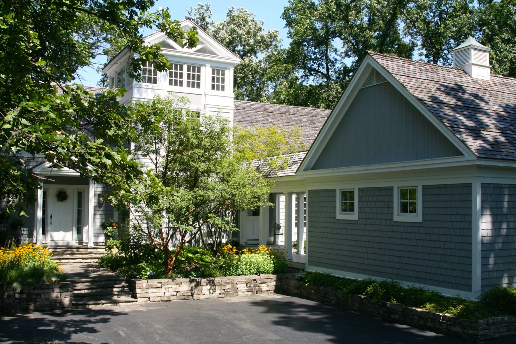 The house among mature trees, its massing broken into separate volumes.